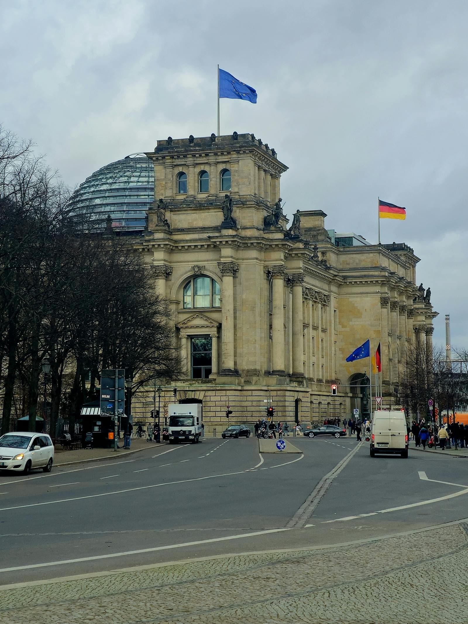 Das Reichstagsgebäude in Berlin mit deutscher und EU-Flagge — Sitz des Bundestags.