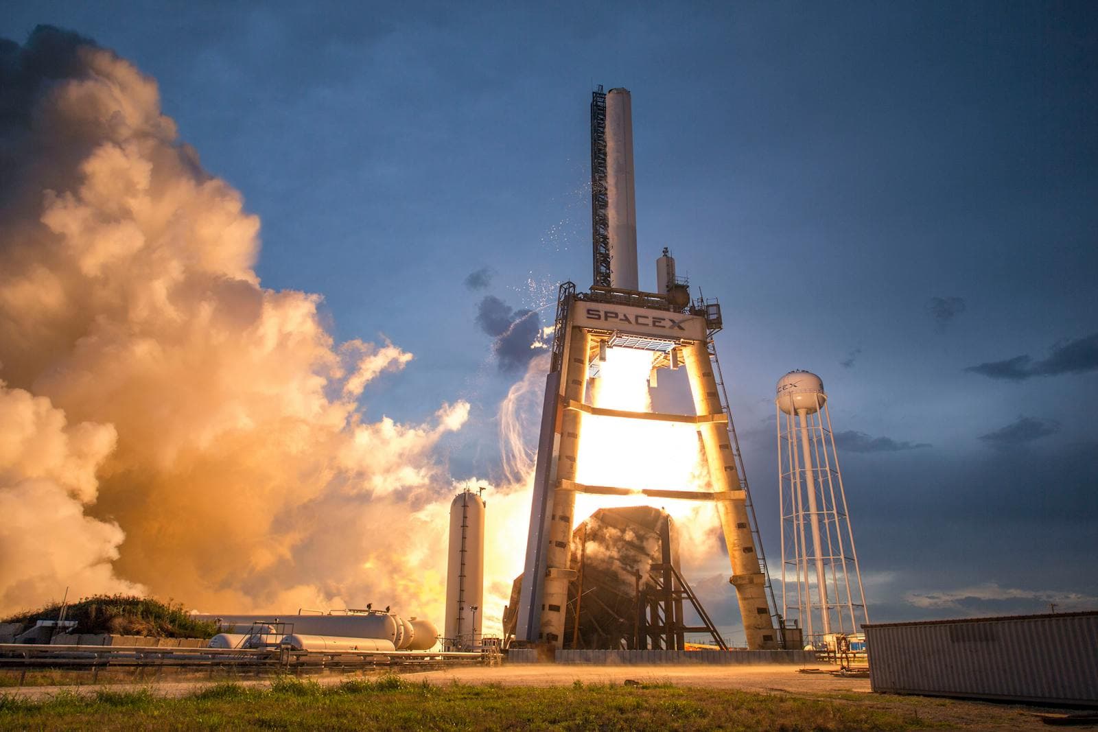 SpaceX rocket lifting off at colourful dusk.