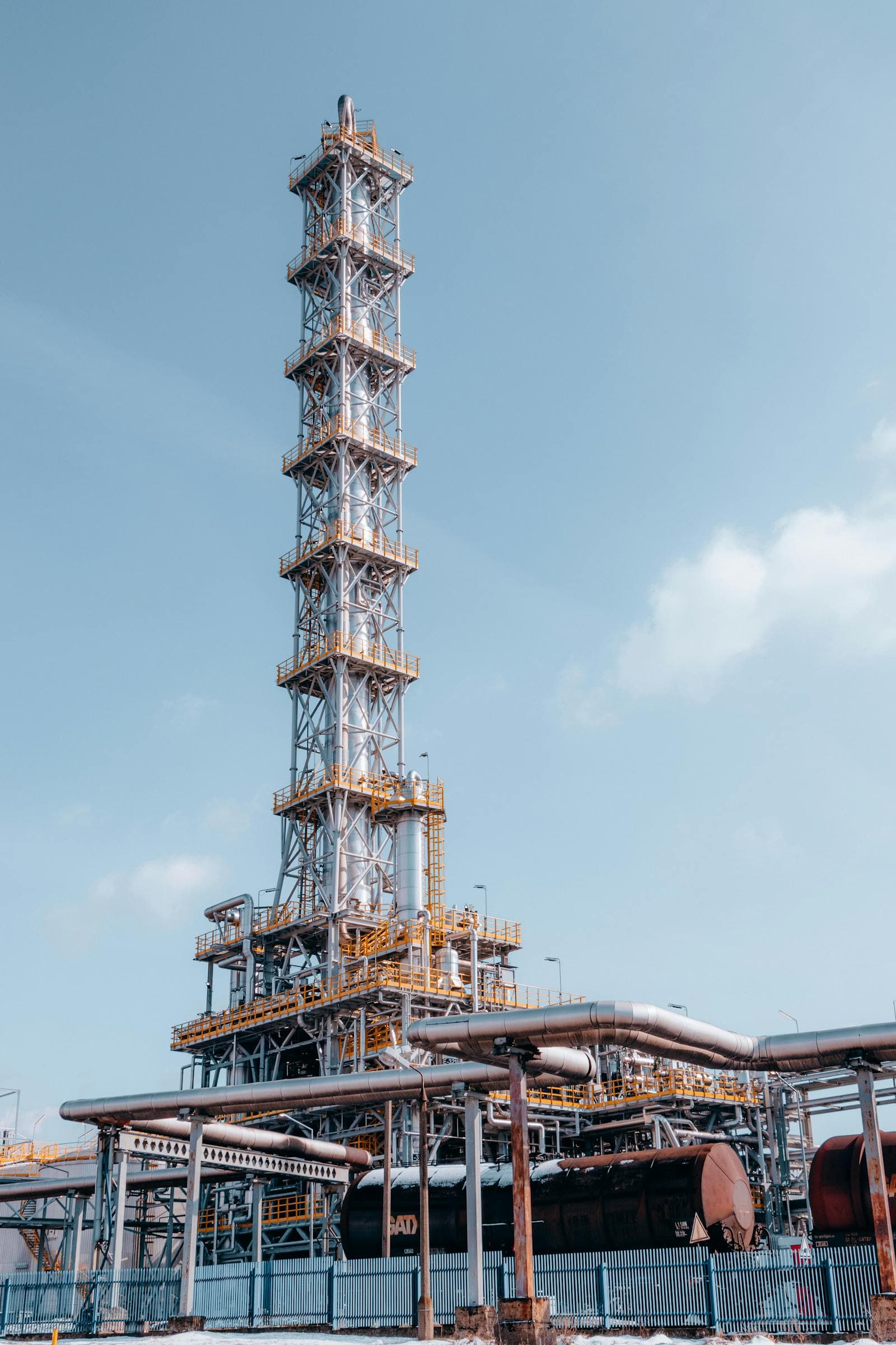 Towering oil refinery infrastructure with stacks and pipes.